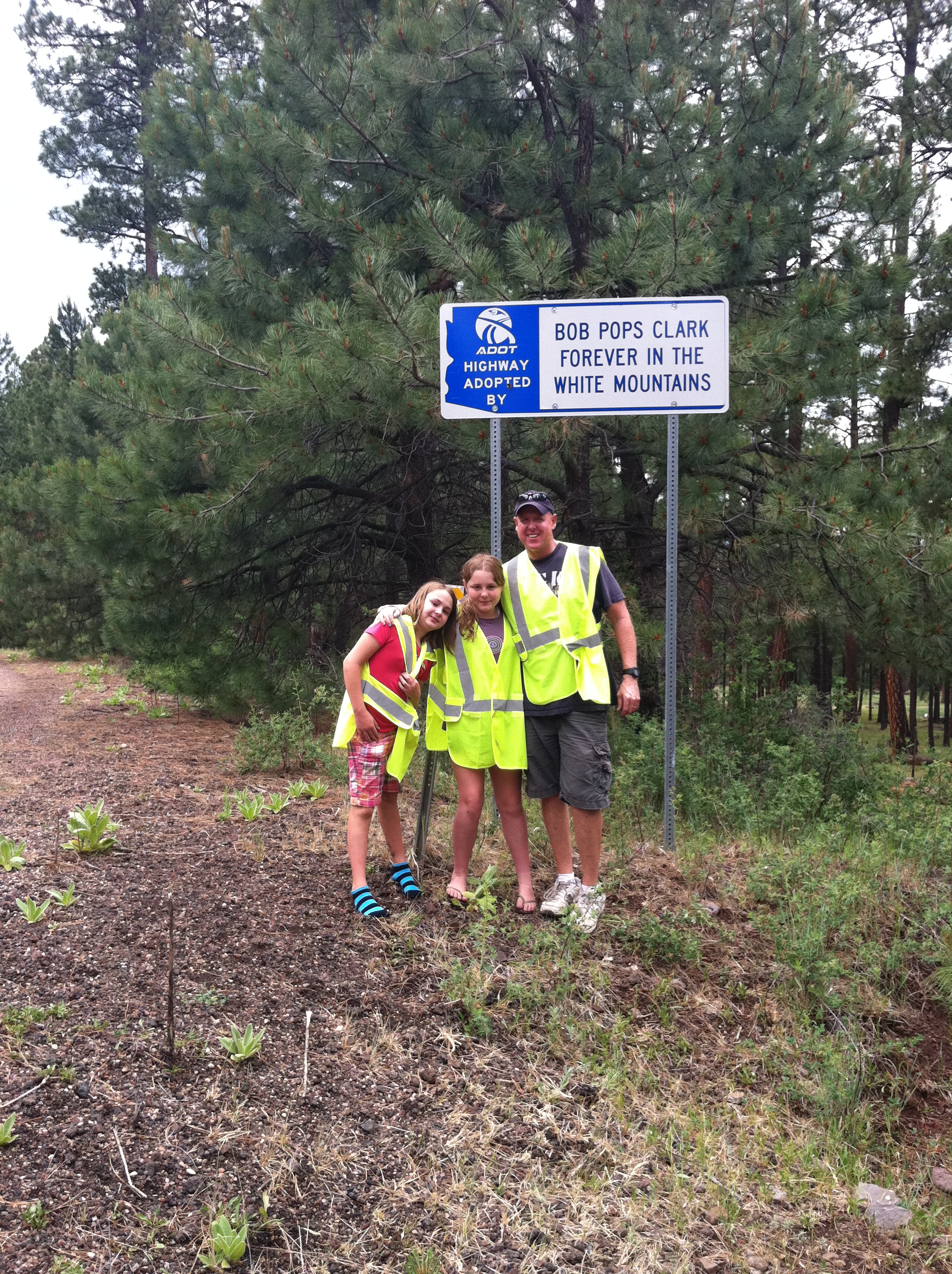 Clark family by Adopt a Highway sign
