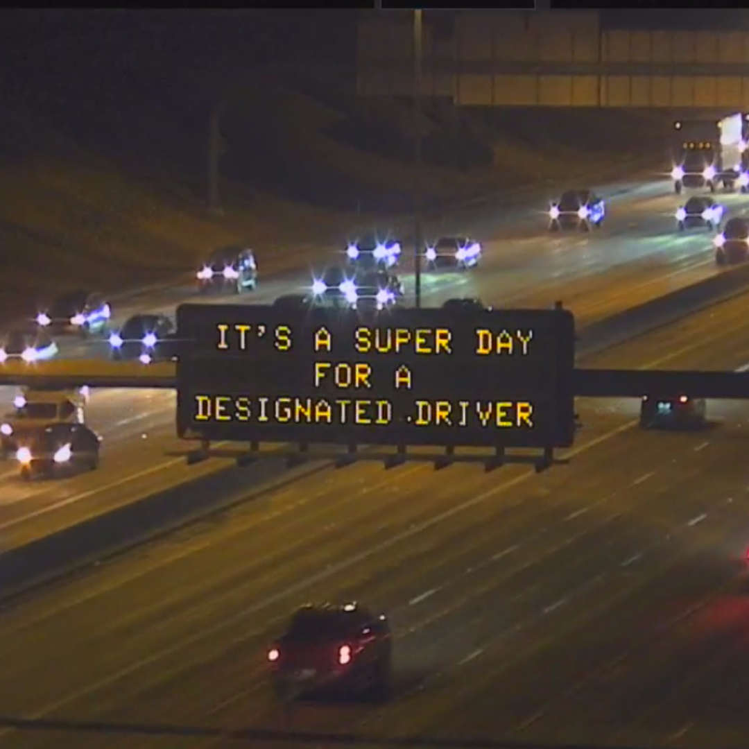 A digital message board on the highway encourages motorists to designate a driver.