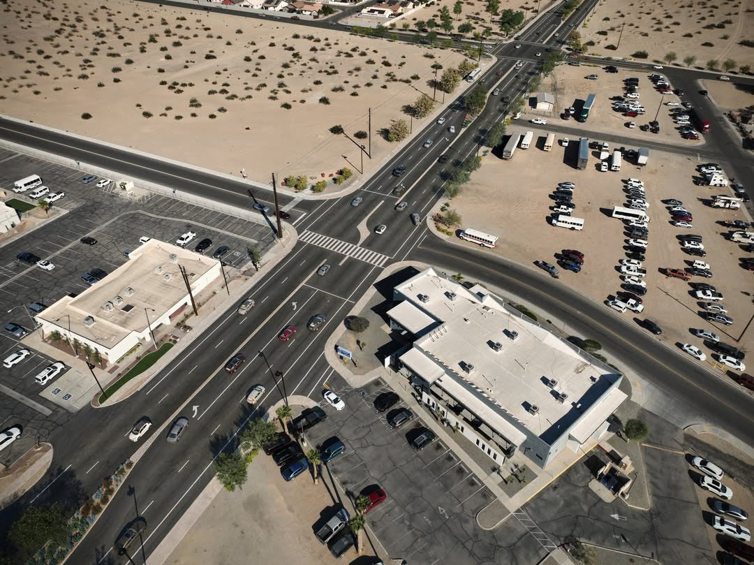Aerial view of the Cesar Chavez Boulevard Improvements project showing a redesigned multi-lane intersection, updated crosswalks, traffic flow improvements, parking areas, and surrounding desert landscape.