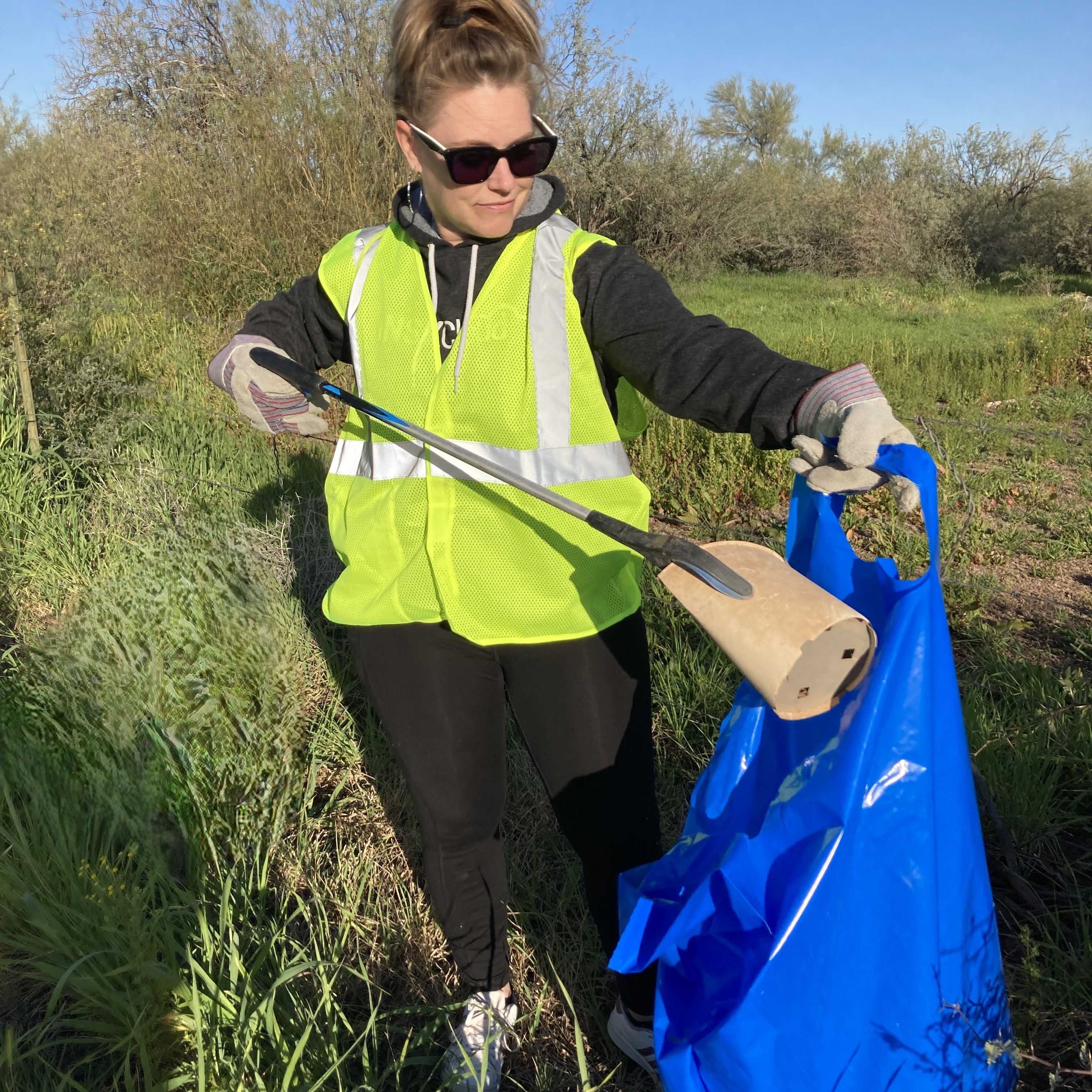 Volunteer placing trash in ADOT bag