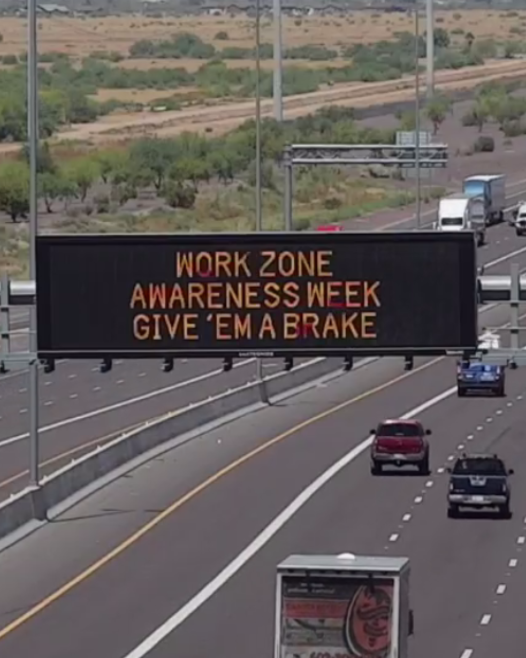 A digital message board on the highway encourages motorists to slow down in work zones.