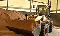 Image of a tractor scooping de-icer 