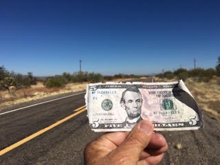 Five dollar bill in hand found during a cleanup