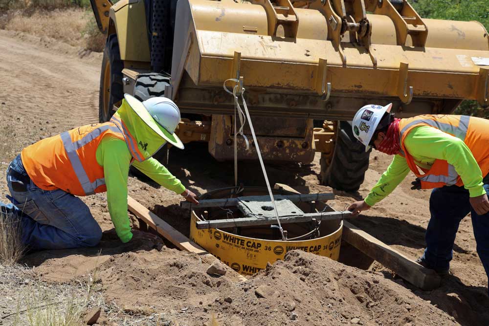 Two men work on footings on the roadside