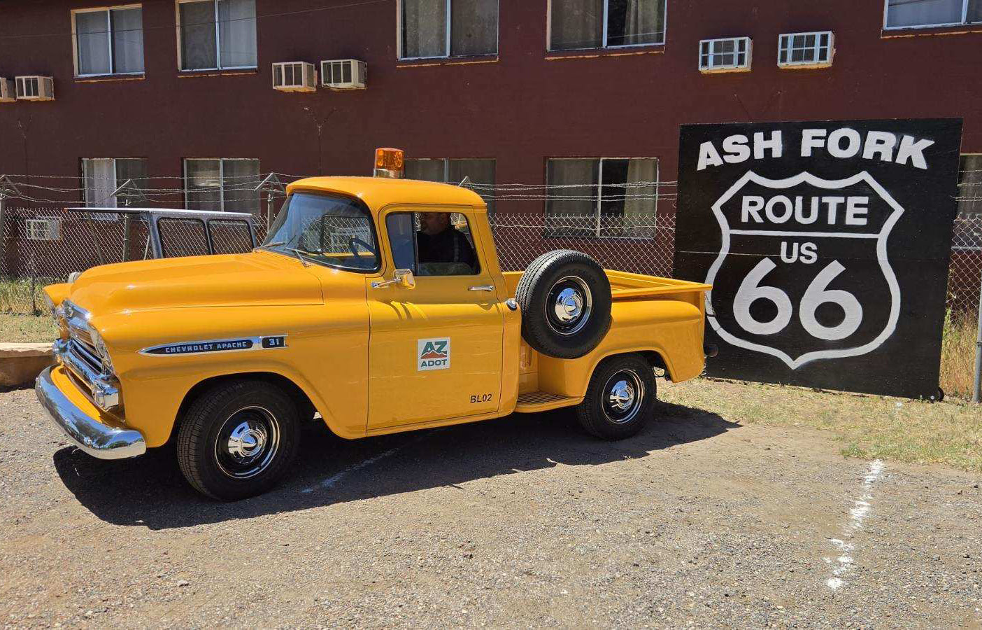 Yellow truck in front of sign that says "Ash Fork Route 66"