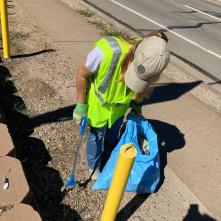 Adopt a highway volunteers picking up trash on the side of a highway