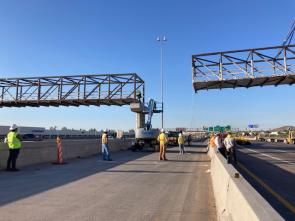 Bridge trusses are constructed above a highway.