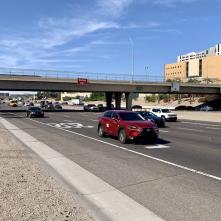 Vehicles drive on a freeway in an urban area.