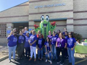 A group of people gather for a photo outside of a building.