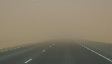 A wall of dust falling onto a highway.