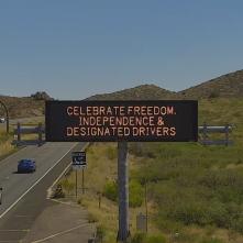 An electronic message board near a highway displays the message, "celebrate freedom, independence and designated drivers."