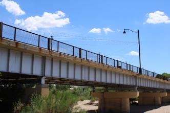 A picturesque bridge spanning a tranquil river, surrounded by lush greenery