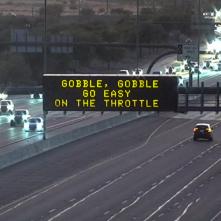 A digital message board on the highway encourages motorists to slow down.