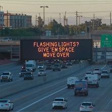 A digital message board on the highway encourages motorists to move over.