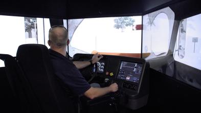 A man operating a snowplow simulator
