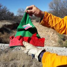 A person holds an elf hat.