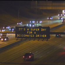 A digital message board on the highway encourages motorists to designate a driver.