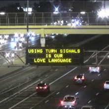 A digital message board on the highway encourages motorists to use their blinker.