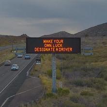 A digital message board on the highway encourages motorists to designate a driver.