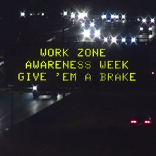 A digital message board on the highway encourages motorists to slow down.