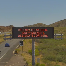 A digital message board on the highway encourages motorists to designate a driver.