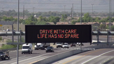 A digital message board on the highway encourages motorists to drive with care