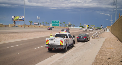 An ADOT truck assisting a stranded motorist on the side of the highway