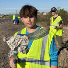 Adopt a Highway volunteer holds up a piece of litter. 