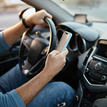 A man driving with a phone in his hand. 