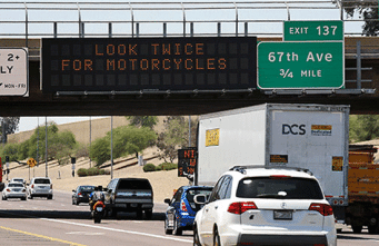 A digital message board on the highway encourages motorists look twice for motorcyclists