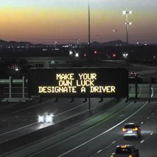A digital message board on the highway encourages motorists to designate a driver.