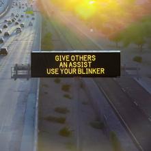 A digital message board on the highway encourages motorists to use their blinker..