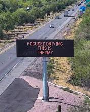A digital message board on the highway encourages motorists to drive focused.