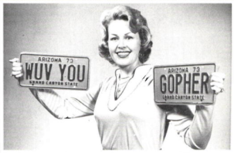 Peggy Wallace holding personalized license plates that say "WUV YOU" and "GOPHER."