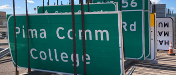 Highway signs are stacked in rows on the ground, waiting to be delivered and installed.