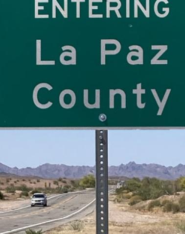 car on highway sign entering La Paz County