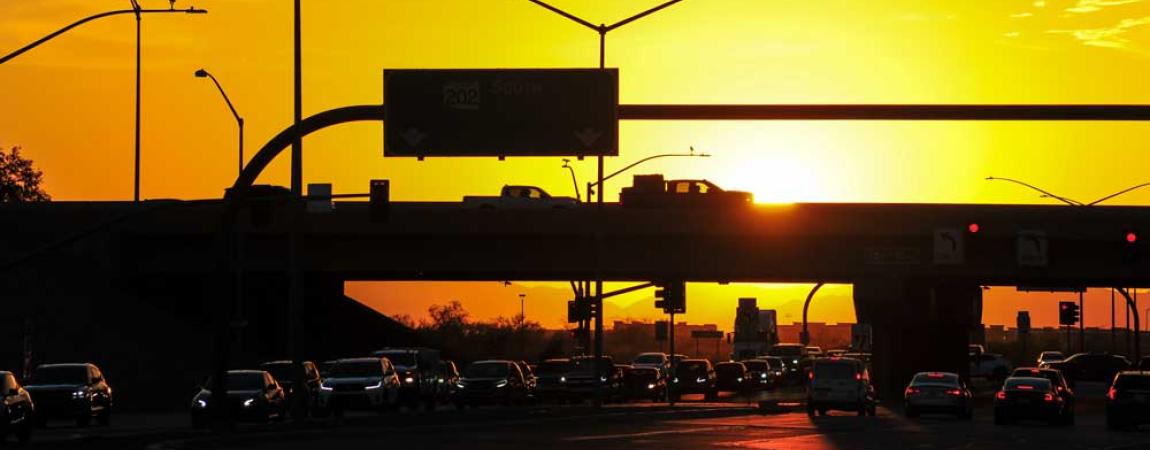 cars on freeway at sunset with a bright orange sky