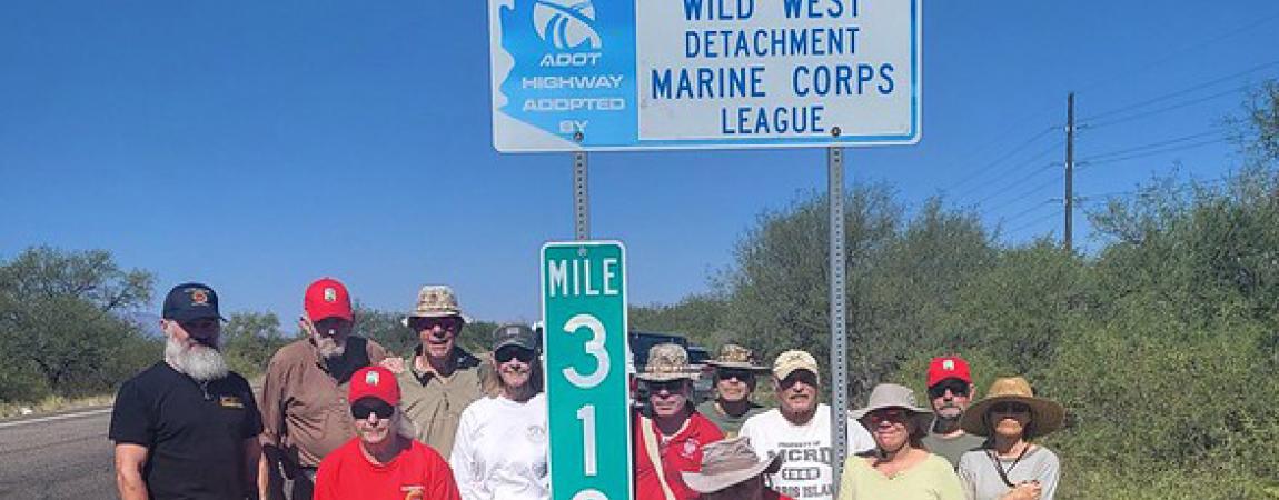 group of people standing around a highway mile marker