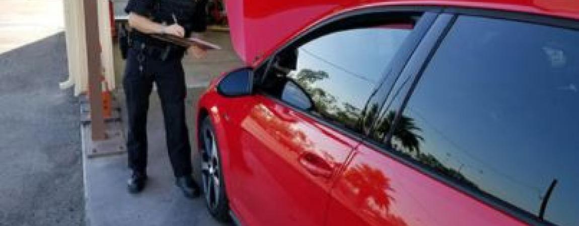 man inspecting a car with its hood open