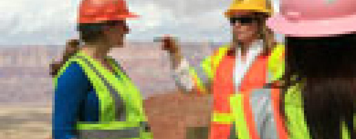 E.P. training - two people outside in hard hats, one explaining to another