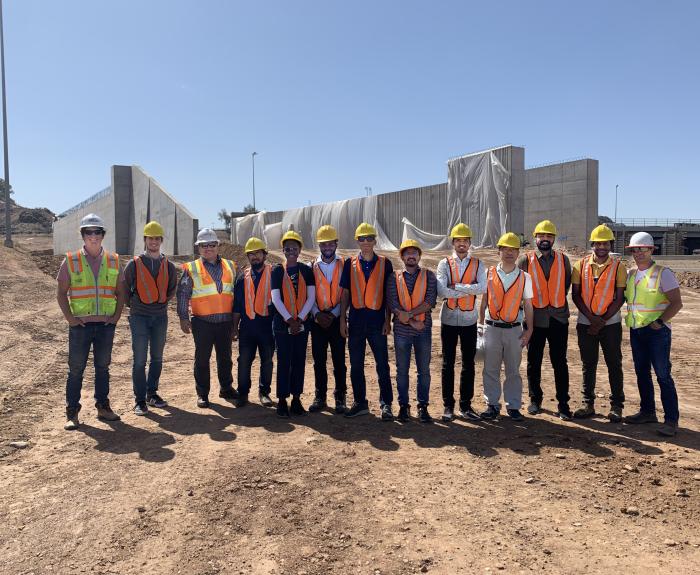 Thirteen people standing in construction safety gear