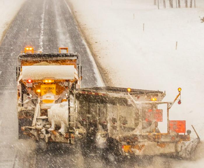 A photo of a snow-plow clearing snowfall on a roadway.