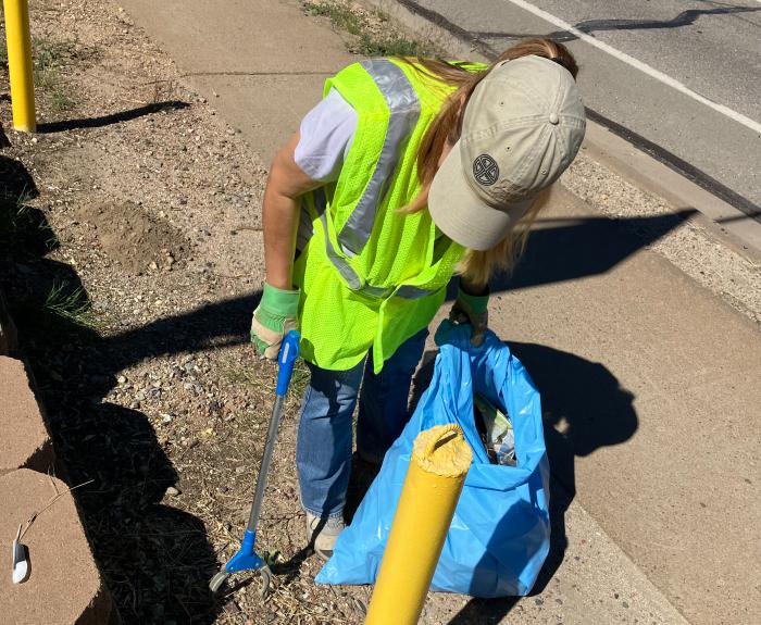 Adopt a highway volunteers picking up trash on the side of a highway