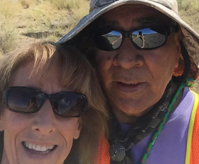 Two people standing in front of an Adopt a Highway sign on State Route 86