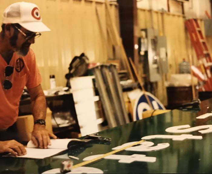 A man works on a sign.