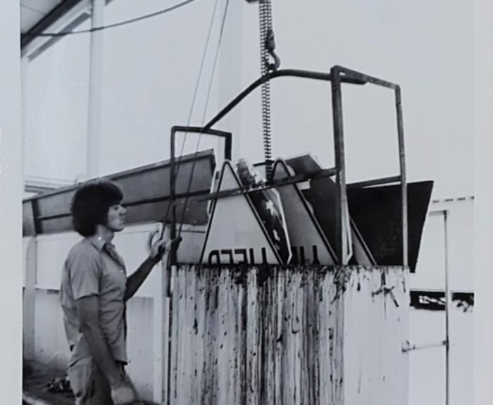 A man puts a sign in a machine.
