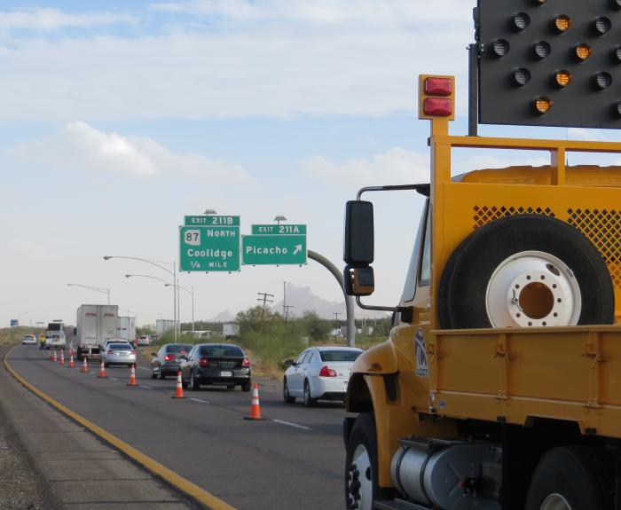 Vehicles drive on a highway past a crash scene. Cones are in the road, giving responders a safe place to work.