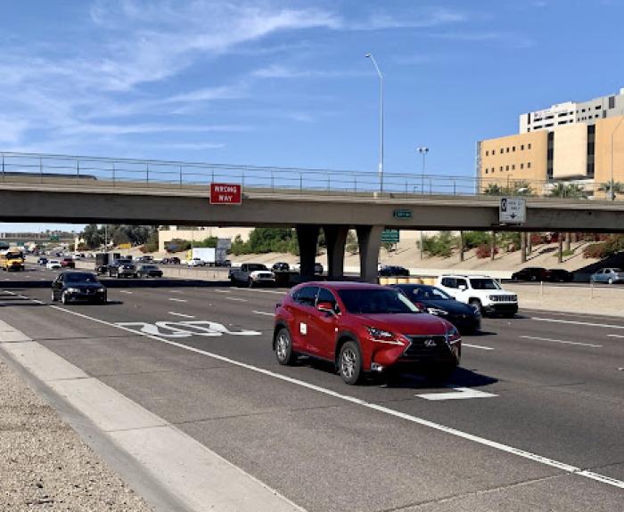 Vehicles drive on a freeway in an urban area.