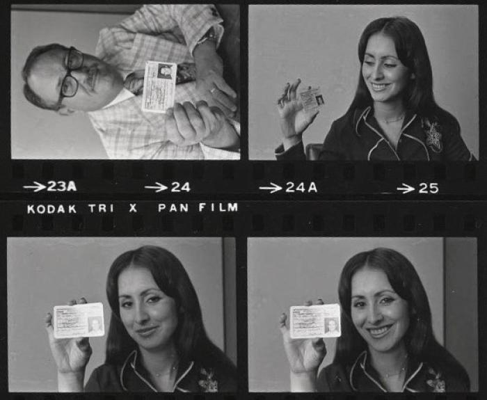 Vintage photo of ADOT employees displaying a new ID card design in 1975.