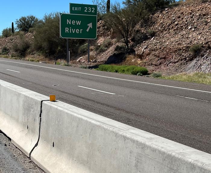 Interstate 17 near the New River exit. A paved roadway with a barrier in the foreground. On the other side of the barrier are where the new flex lanes are being constructed.